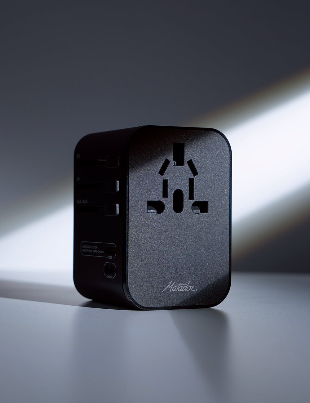black travel adapter in moody studio lighting