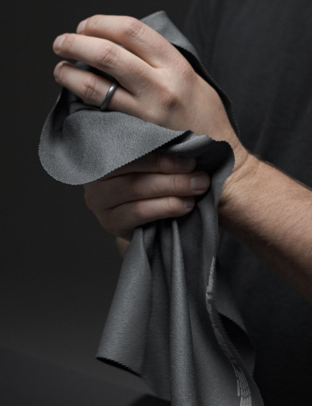 hands in dark studio, wiping clean with towel