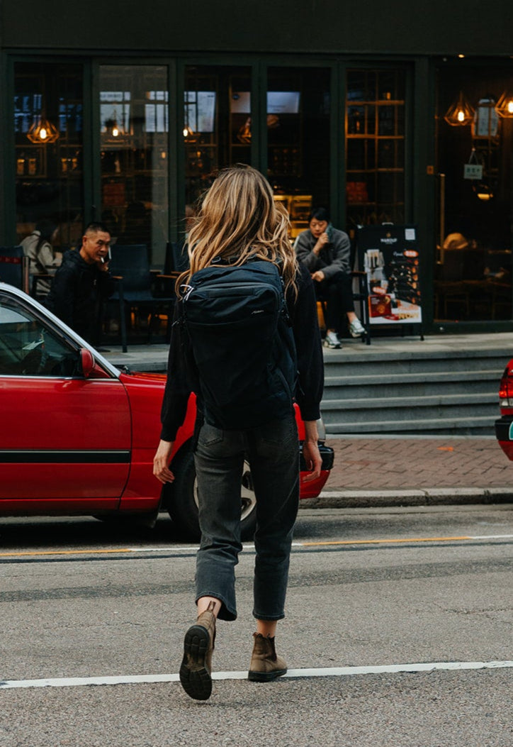 woman crossing the street with a backpack