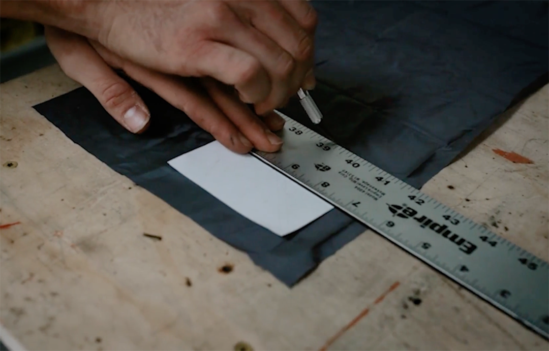 two hands measuring a product and cutting fabric